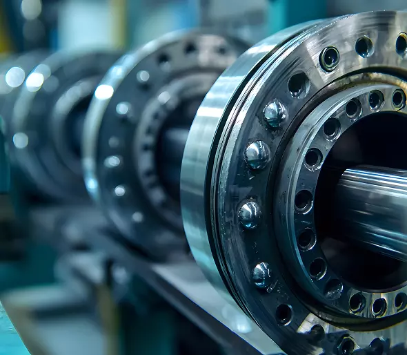 Equilibratura dinamica. Dettaglio ravvicinato di un assemblaggio industriale che mostra cuscinetti metallici lucidi e parti rotanti in un contesto di produzione.